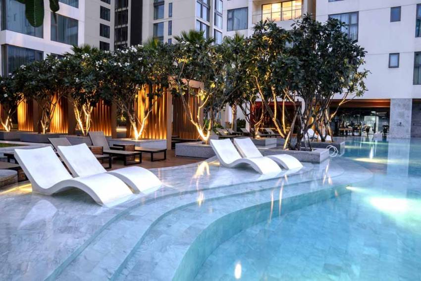 Clear blue swimming pool, green garden, children's play area at Gateway Thao Dien